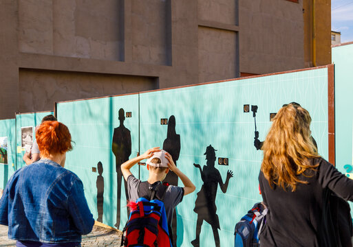 Tourists posing with shadow puppets on interactive wall display