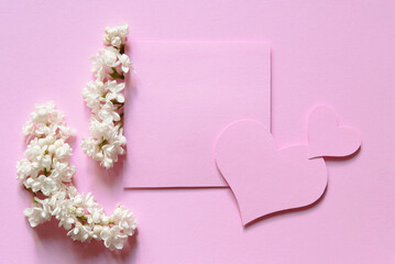 White flowers on pastel pink background. Minimal flat lay top view composition.