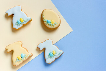 Fototapeta premium Easter homemade baked gingerbread with different pattern of icing or cookies in the shape of bunny and eggs. Light background, top view, copy space