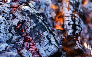 Glowing embers in hot red color, abstract background. The hot embers of burning wood log fire.