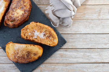 Traditional Spanish torrijas for Holy Week on wooden table. French Toast. Top view. Copy space