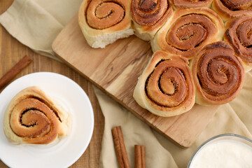 Freshly baked cinnamon rolls on wooden table, flat lay
