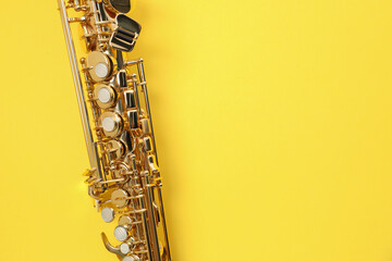 Naklejka premium Jazz. One saxophone on yellow background, top view. Space for text