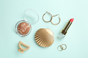 Stylish accessories and lipstick on light blue background, flat lay