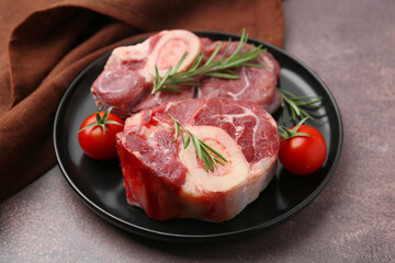 Pieces of raw beef, rosemary and tomatoes on brown textured table, closeup