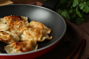 Tasty fried gyoza (dumplings) on table, closeup
