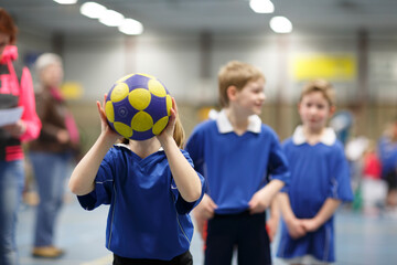 Kids participate in a fun indoor handball practice session at a local sports facility in early spring