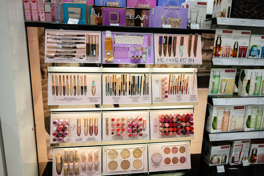 Cosmetic product display shelf featuring luxury Naj Oleari brands and vibrant packaging designs