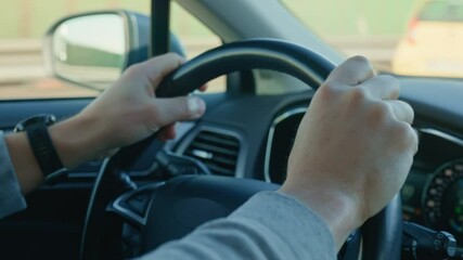 Close-up of male driver driving car, gripping steering wheel and turning on turn signal before overtaking. Concept of travel, transportation and road safety