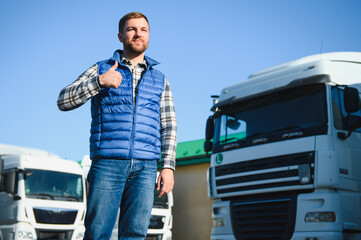 Happy confident male driver standing in front on his truck
