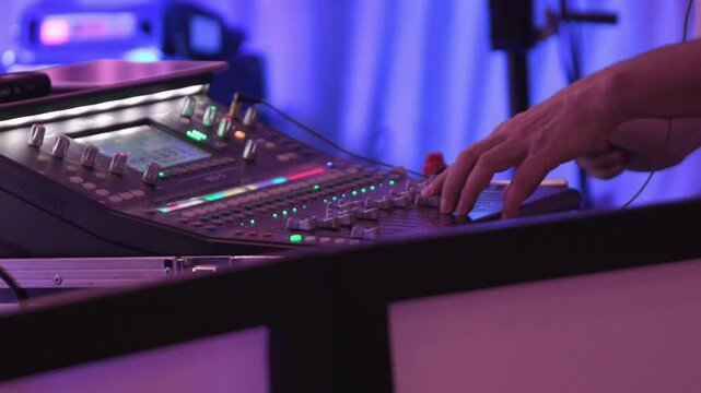 A skilled Sound Mixer works at an event with vibrant lighting and various controls
