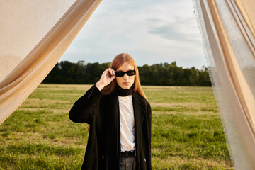 Handsome young man with long hair creates a striking fashion moment in a natural setting