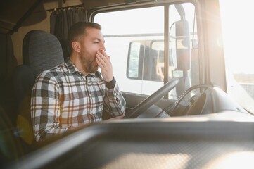 Tired truck driver feeling sleepy and yawning while driving