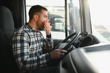 Tired truck driver feeling sleepy and yawning while driving