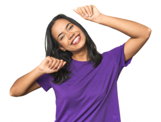 Young Latina posing in studio celebrating a special day, jumps and raise arms with energy.