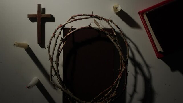 blowing out a candle. Crown of thorns, bible, cross and candles representing christian faith