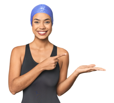 Pro Latina swimmer in studio gear excited holding a copy space on palm.