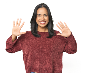 Simple portrait of a young Latina showing number ten with hands.