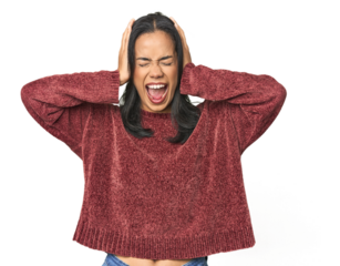 Simple portrait of a young Latina covering ears with hands trying not to hear too loud sound.