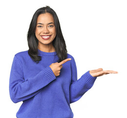 Simple portrait of a young Latina excited holding a copy space on palm.