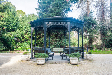 Elegant gazebo surrounded by lush greenery in a serene park setting