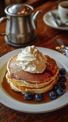 Delicious pancakes with whipped cream, syrup, and fresh blueberries