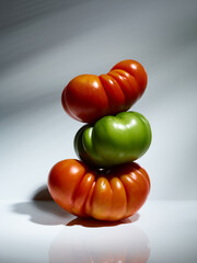 Sweet farm tomatoes stacked over grey background