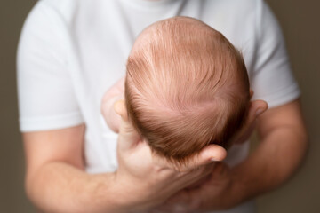 Close-up of a newborn baby's head held gently