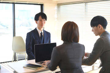 企業の面接を受けるスーツ姿のアジア人男性