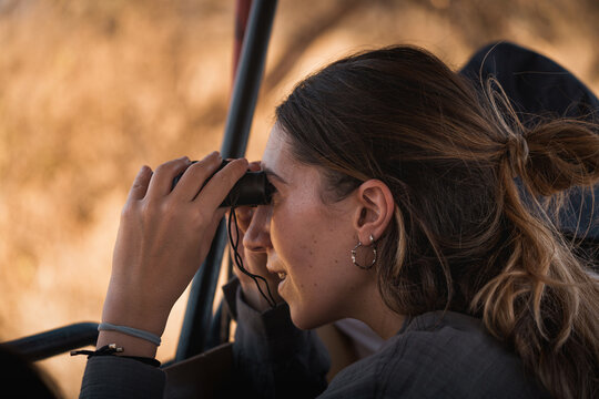 Tourist observing wildlife with binoculars during safari in tarangire national park