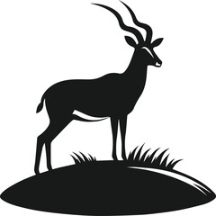 silhouette of an antelope standing on a small hill