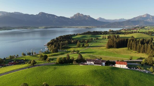Flight towards reservoir lake Forggensee with mountain alps panorama, Germany