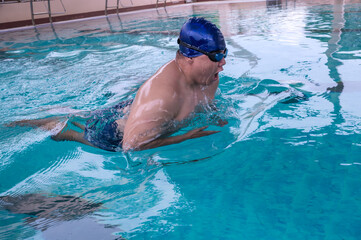 Fat Asian male swimmer swimming breast stroke action in pool
