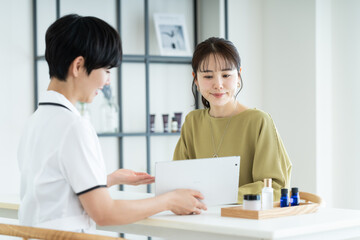 エステサロンで肌の相談をする若い女性
