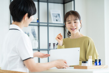 エステサロンで肌の相談をする若い女性