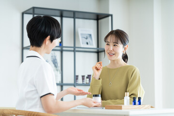 Obraz premium エステサロンで肌の相談をする若い女性