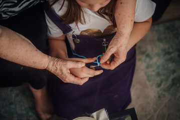 Grandmother teaching granddaughter how to embroider