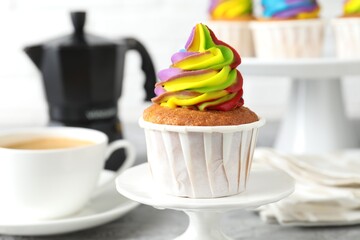 Delicious cupcake with colorful cream on stand, closeup