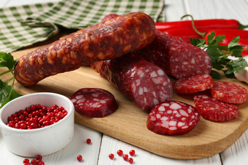 Different smoked sausages and spices on white wooden table, closeup