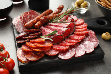 Different smoked sausages slices served on grey table, closeup