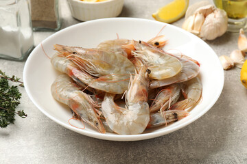 Fresh raw shrimps and spices on grey table, closeup
