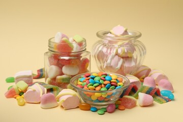 Many different tasty candies on beige background