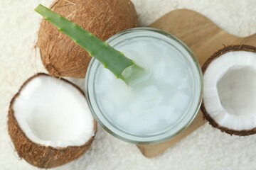 Refreshing drink with coconut and aloe on white textured table, flat lay