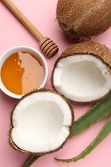 Hair treatment. Fresh coconut, honey and aloe leaves on pink background, flat lay