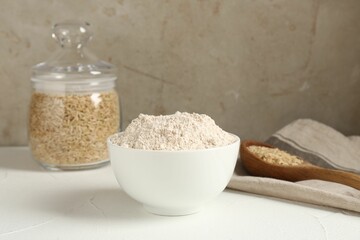 Brown rice and flour on white table. Space for text