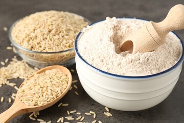 Brown rice and flour on grey table, closeup