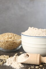 Brown rice and flour on grey table, closeup. Space for text