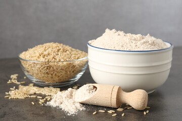 Brown rice and flour on grey table, closeup