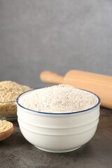 Brown rice flour on grey table, closeup. Space for text
