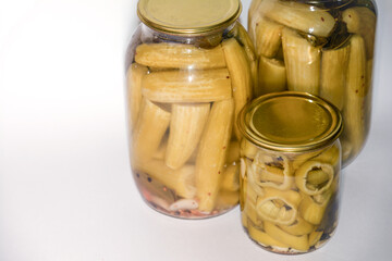 Vegetable marinade on white background. Canned sour vegetables in glass jars. Pickled vegetables in a jar - cucumbers, tomatoes, peppers, okra.